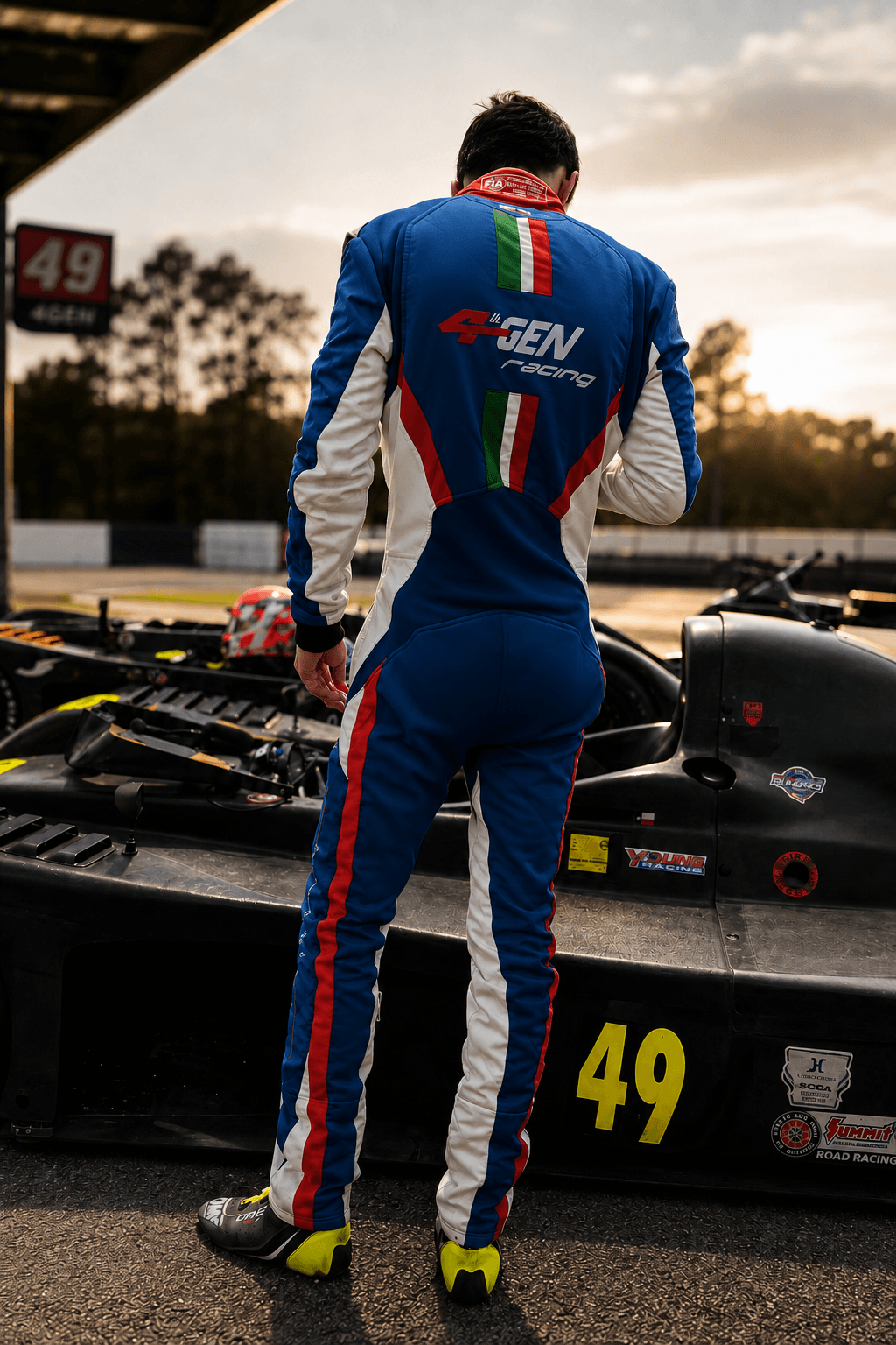 Filippo Massa standing beside race car number 49 at sunset