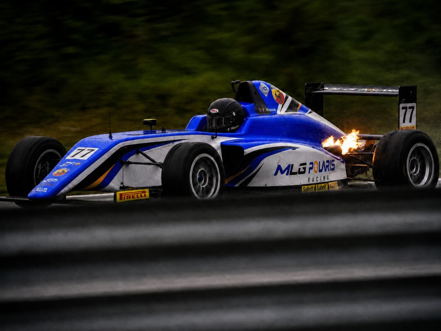 Blue formula car number 77 with exhaust flame