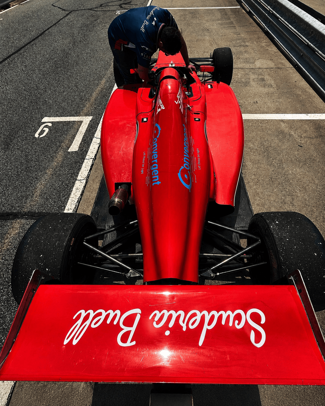 Red formula car overhead during preparation