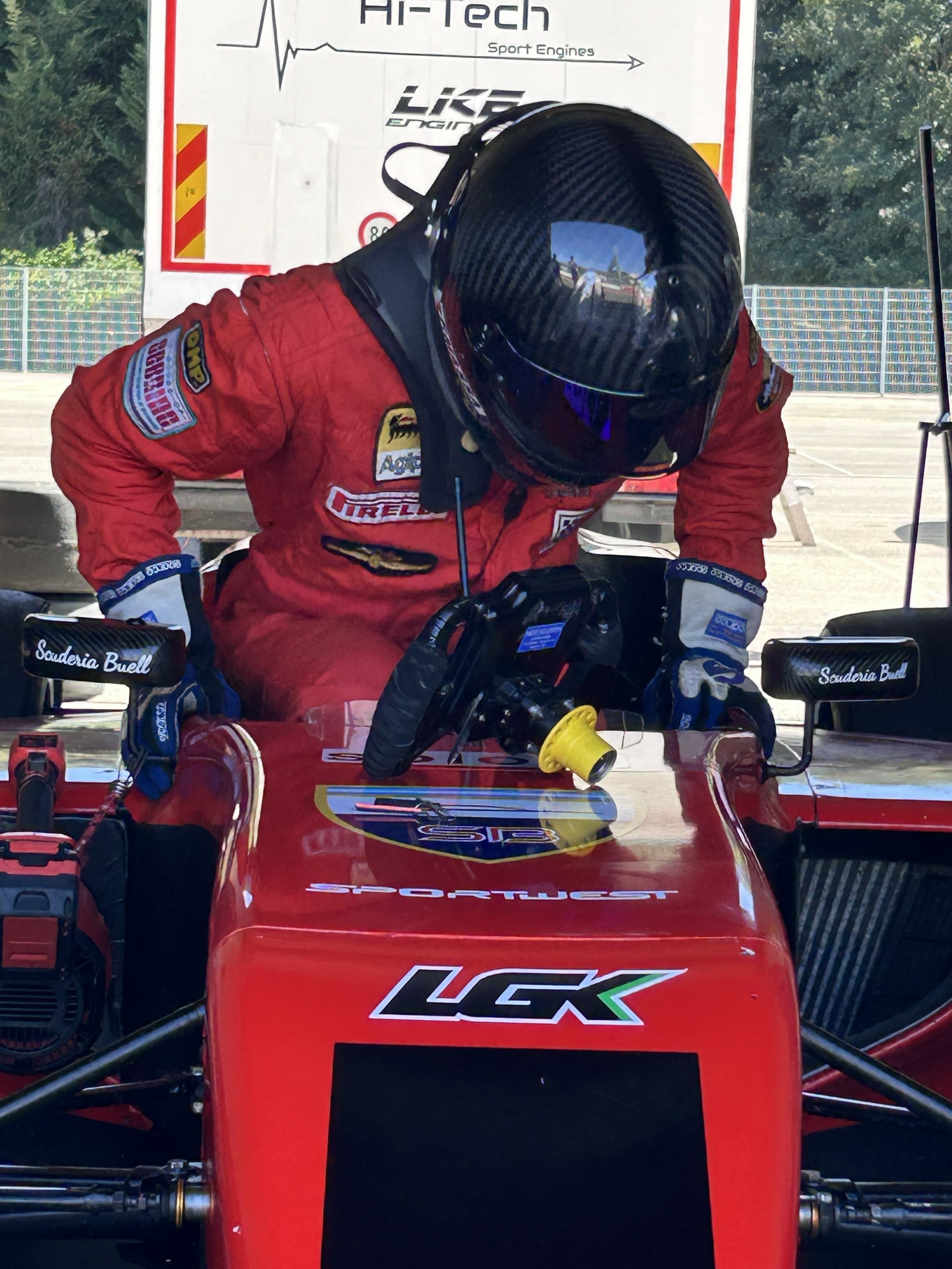 Filippo Massa entering a red formula car during preparation