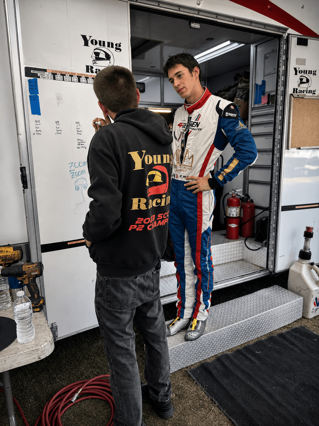 Filippo Massa discussing strategy beside a race trailer whiteboard