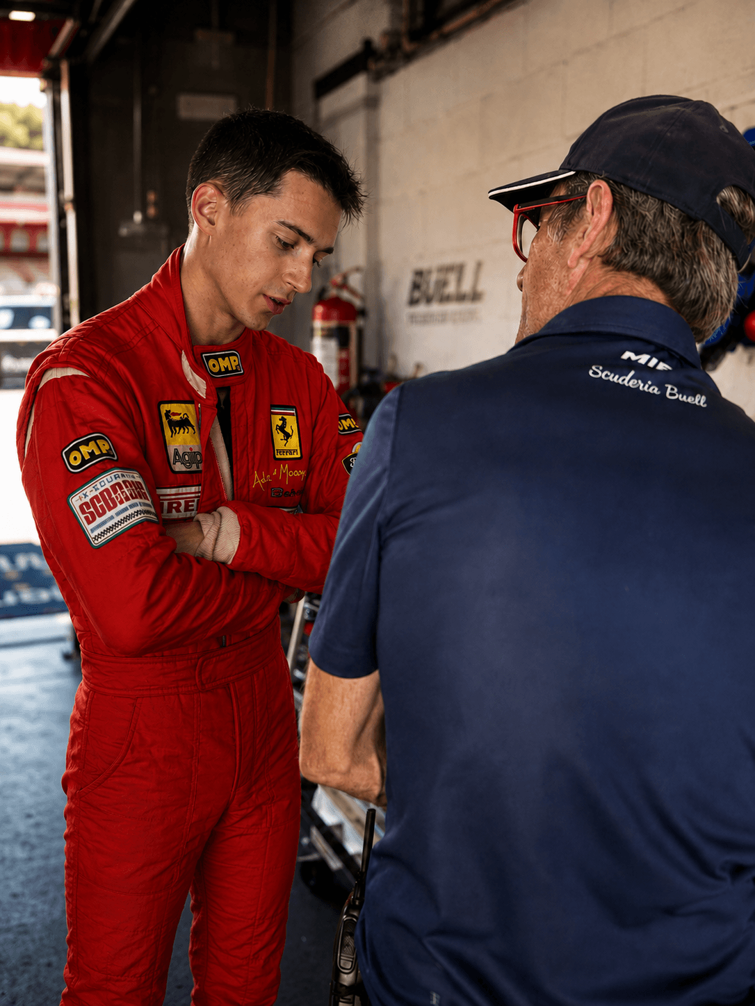 Filippo Massa in race suit discussing feedback in the garage