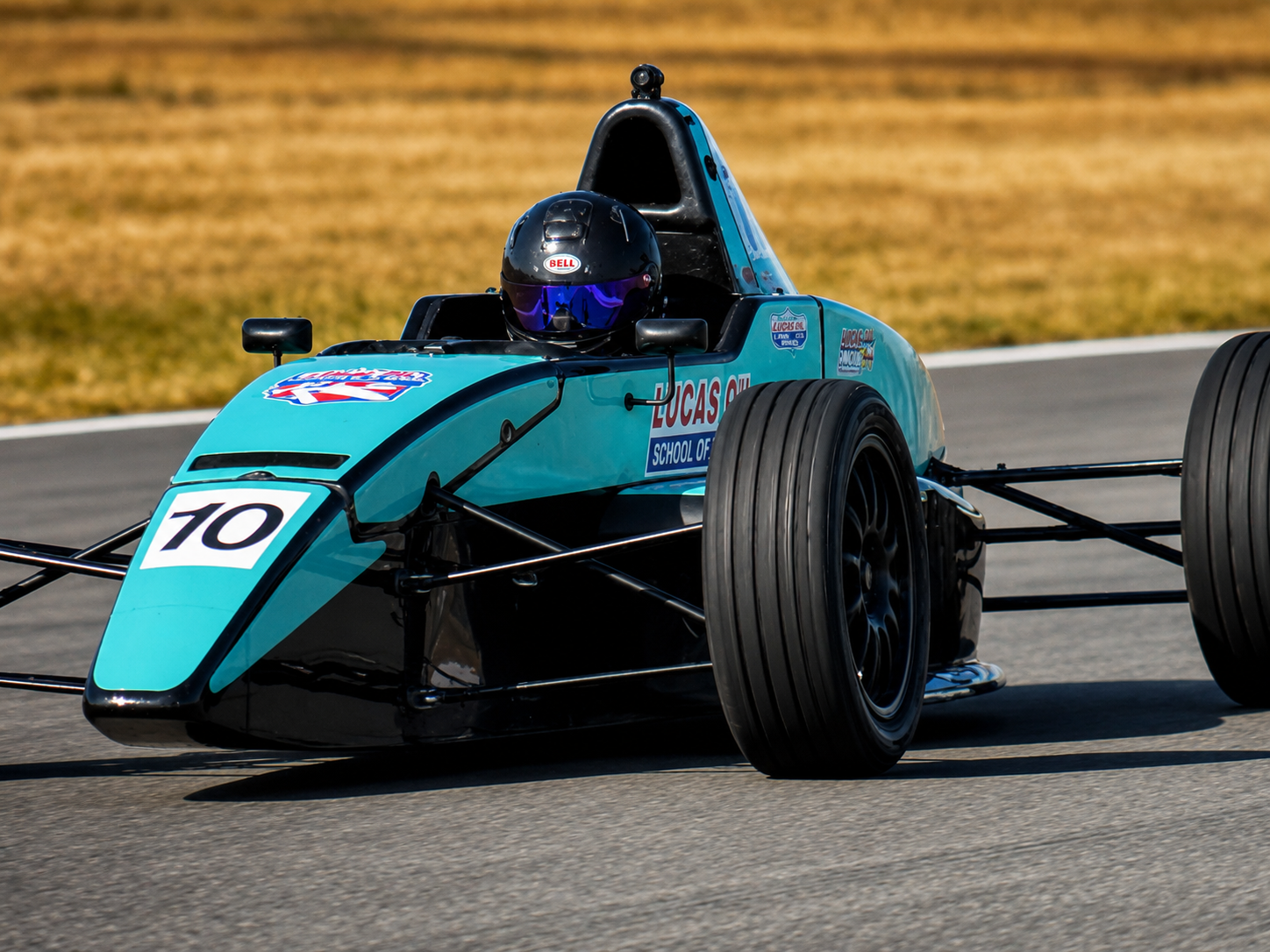 Turquoise formula car number 70 cornering on track
